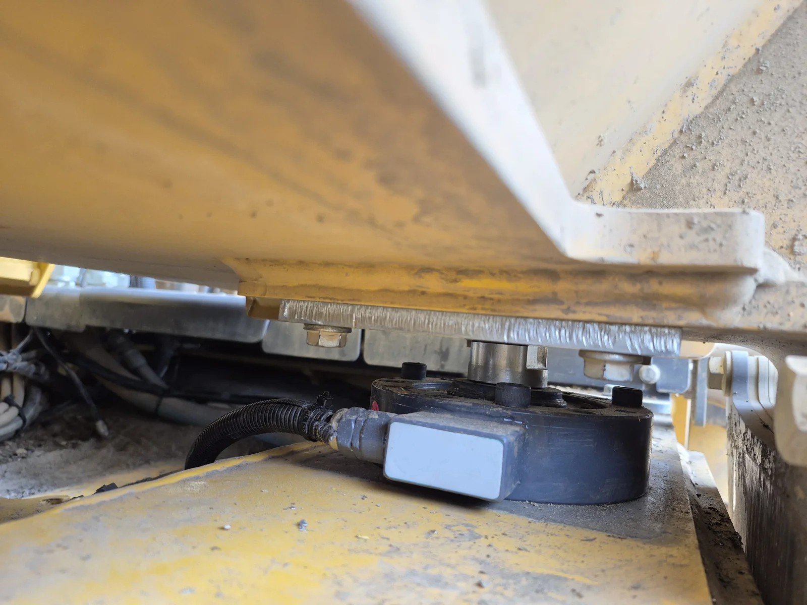 Onboard weighing installation on a dump truck showing load cell configuration and operator display